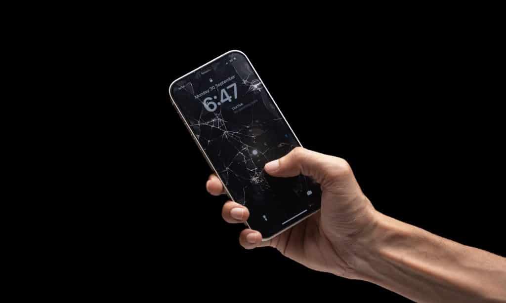 Zaštitno staklo ili folija za telefon prikazani na pametnom telefonu u ruci, sa vidljivim oštećenjima na ekranu kao primer potrebe za dodatnom zaštitom.
