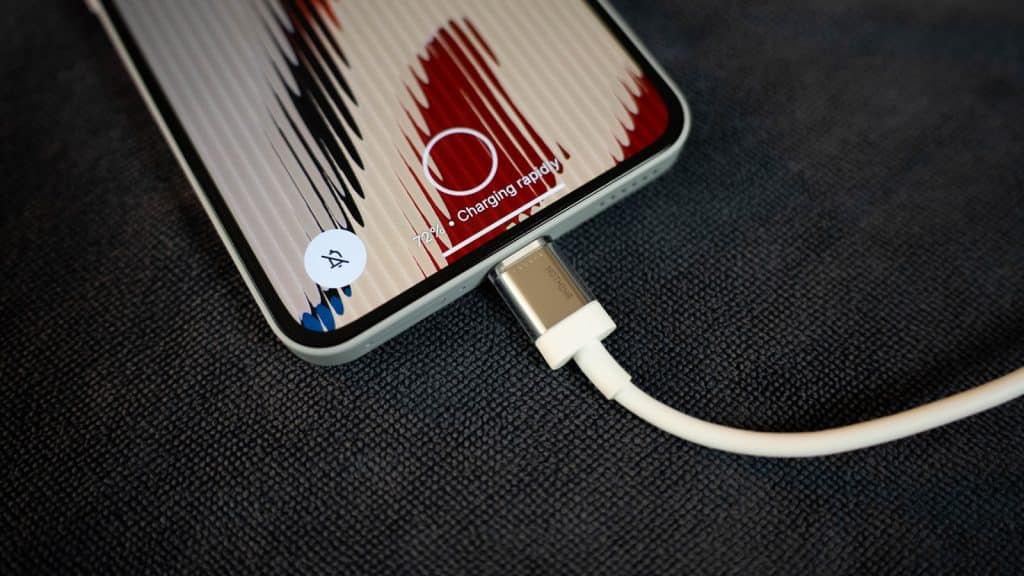 Pravilno korišćenje punjača prikazano kroz pametni telefon povezan sa kablom za punjenje, kao primer bezbednog i ispravnog punjenja uređaja.