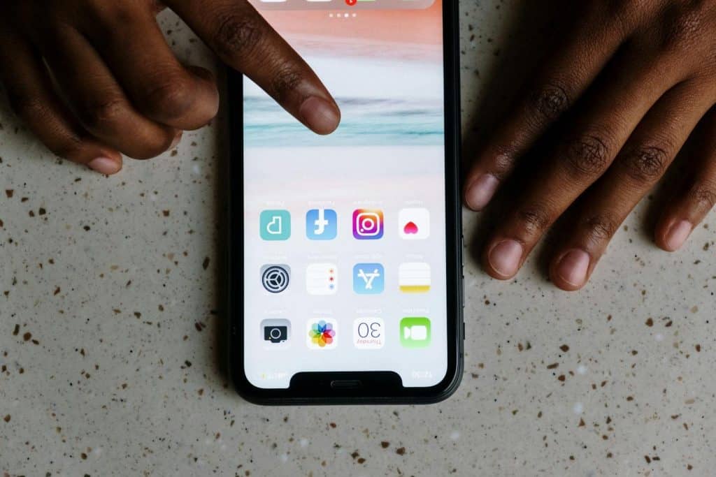 Osoba koristi pametni telefon sa oštećenim prikazom na ekranu, ilustracija usluge reparacija ekrana i rešavanja problema sa touch funkcijom.