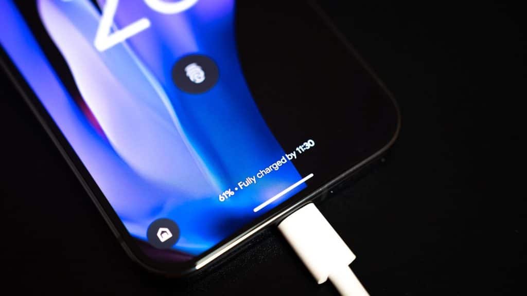 A close up of a cell phone with a charger