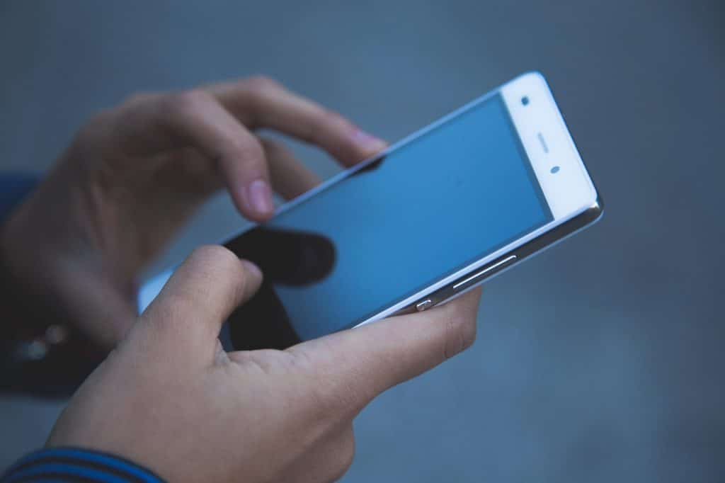 Žena koristi mobilni telefon i proverava bekap podataka pre odlaska u servis