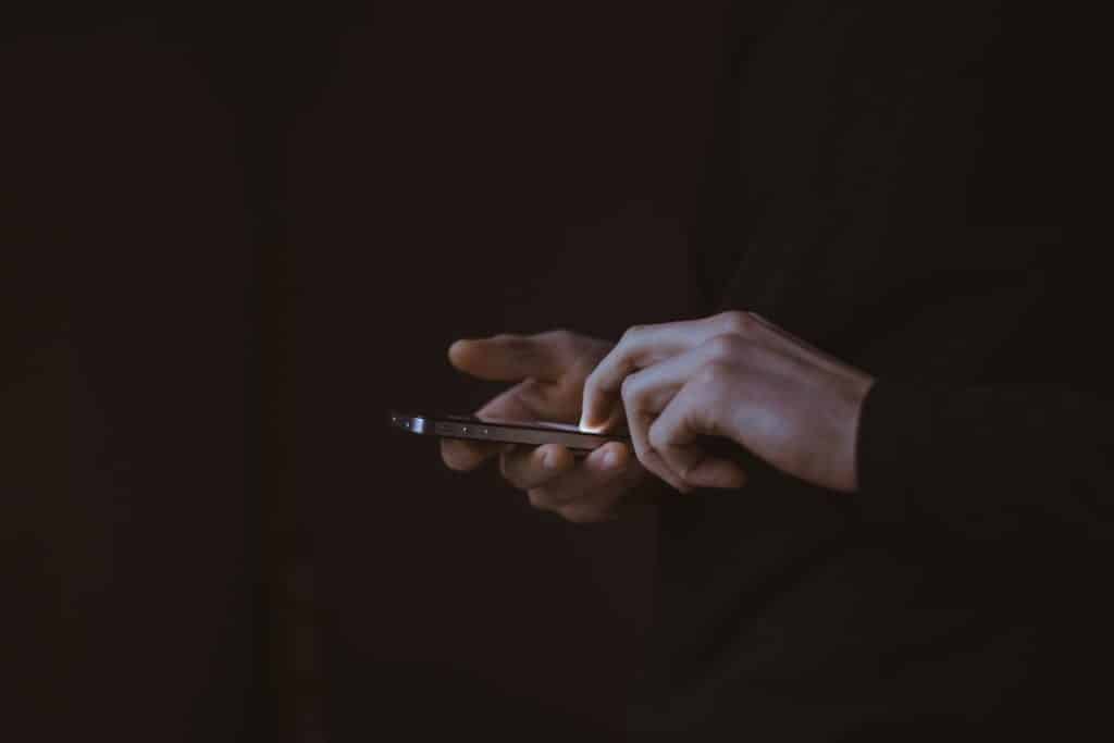 Osoba koristi mobilni telefon dok proverava simptome softverskog ili hardverskog kvara