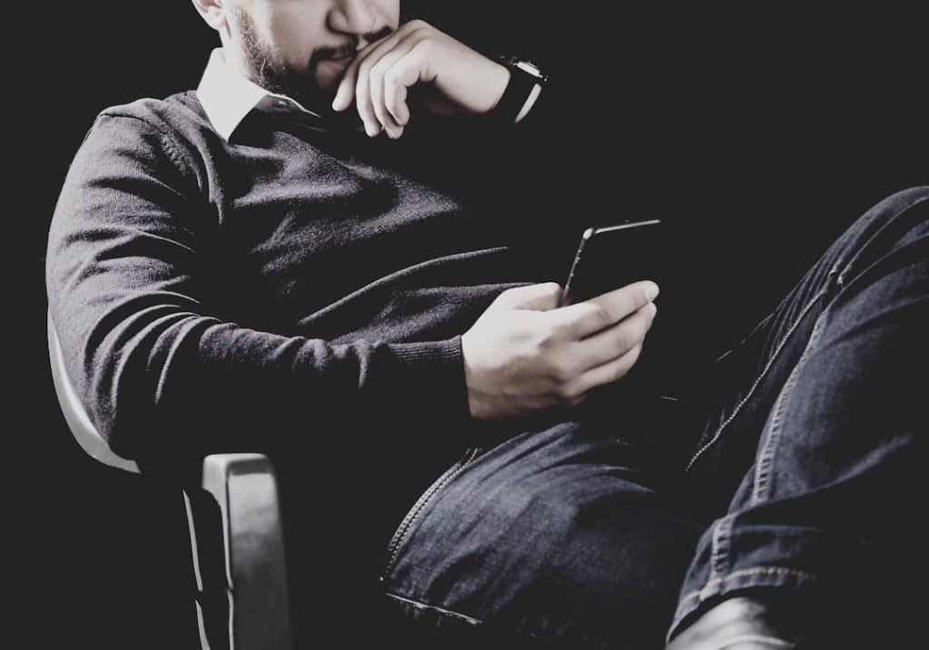 Muškarac gleda u mobilni telefon sa problemima nakon ažuriranja softvera i sporijeg rada