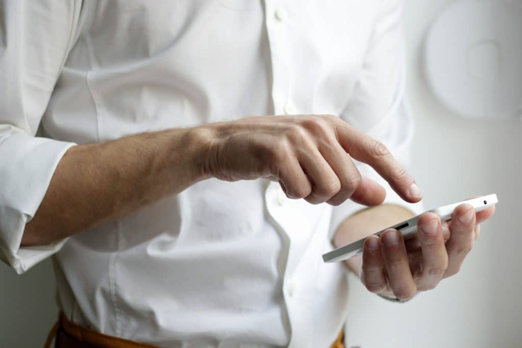 Osoba koristi pametni telefon jednom rukom, ilustracija problema i habanja koje može izazvati oštećen konektor za punjenje na mobilnom uređaju.