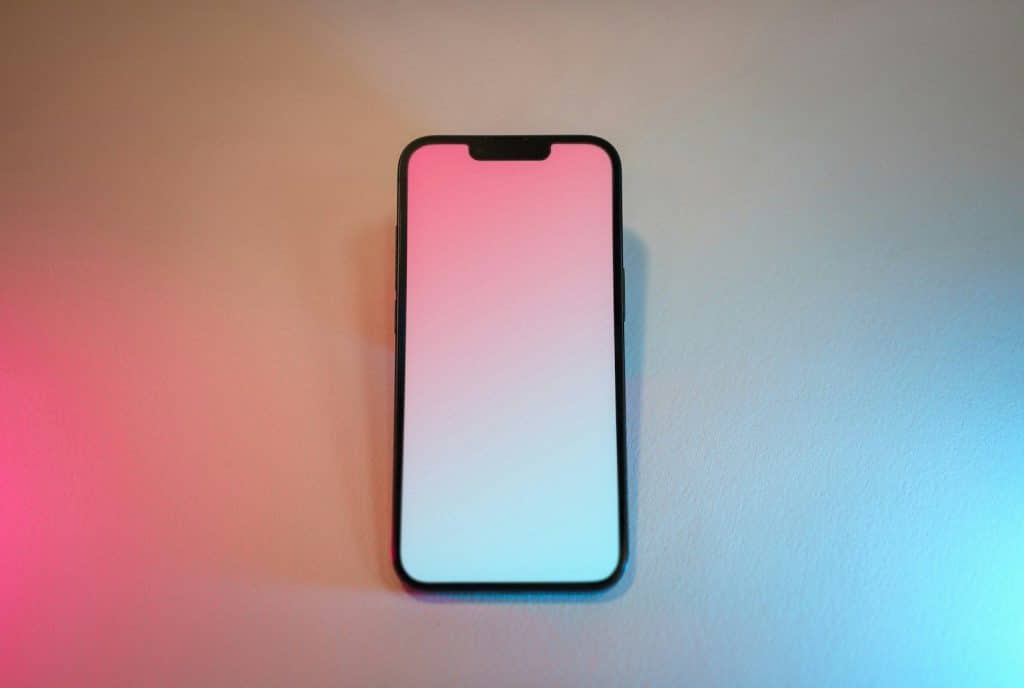 Pametni telefon sa osvetljenim ekranom na pastelnoj pozadini, ilustracija problema kada ekran ne reaguje na dodir ili komande korisnika.
